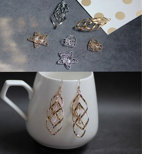 Détail macro de breloques cœur et étoile évidées plaquées or 18 carats sur céramique