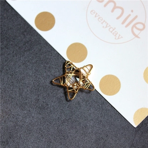 Vue macro de breloques étoiles en fil plaqué or 18K avec centre clair pour bijoux DIY