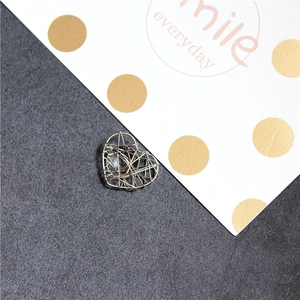Gros plan d'un pendentif cœur en fil d'argent fait main avec un design évidé complexe