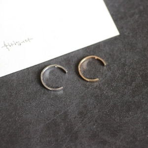 Minimalistische offene Ringe in Silber und Roségold auf dunkler Steintextur platziert