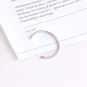 Minimalistische zilveren open metalen armband op een eenvoudige witte achtergrondkaart