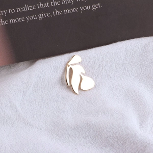 Polierter goldener Ginkgoblatt-Anhänger für DIY-Schmuck auf weißem, strukturiertem Stoff