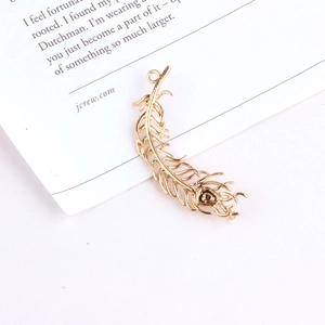 Detailopname van een 18K vergulde bladvormige hanger met fijne verentextuur en oog