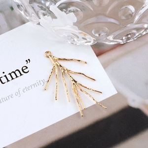 Macro detail of 18K gold plated branch pendant with natural texture and hanging loop