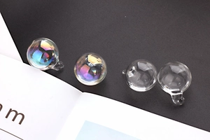 Close-up of DIY iridescent and clear glass water ball charms for earring making
