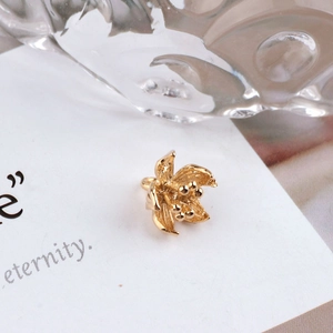 Macro detail of 18K gold plated peacock branch flower pendant with brushed texture petals