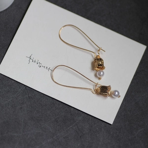 Detailed view of lily of the valley earrings with 18K gold branch and pearl charms