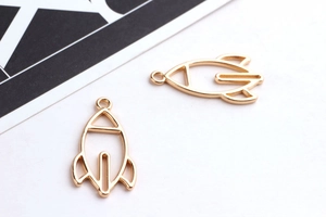 Close-up of golden rocket alloy pendants for DIY earrings and jewelry making