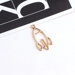 Macro detail of a hollow golden rocket charm for DIY jewelry and earring making