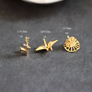 Vue macro de pendentifs dorés en forme de cerf et grue avec dimensions précises