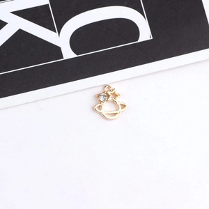 Macro detail of golden Saturn charm with sparkling rhinestone star for DIY jewelry