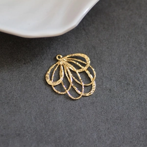 Détail macro du pendentif éventail plaqué or avec finition martelée pour bijoux DIY