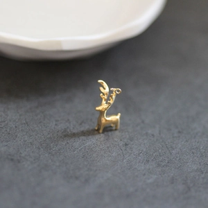Vue macro d'un pendentif cerf doré 3D avec bois et boucle pour création de bijoux
