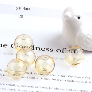 Detailed close-up of 13x14mm light yellow hollow glass bead for DIY jewelry making