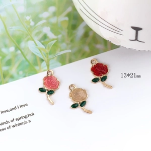 Dettaglio di ciondoli a rosa smaltata 13x21mm in rosso, rosa e crema con foglioline
