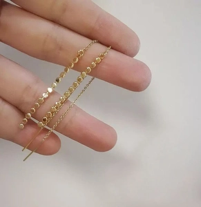 Detailed view of 18K gold plated long tassel chain earrings with flat round bead details