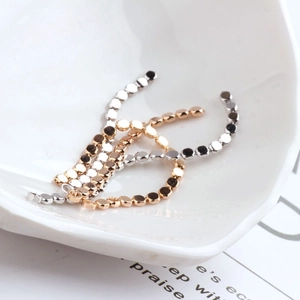 Detail of 18K gold and silver plated flat bead chains on a decorative shell plate