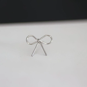 Macro shot of silver bow earring components with a high-polished metallic finish