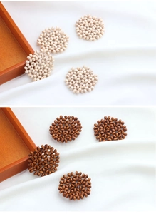 Detail of hand-woven round wooden bead pendants in cream and reddish brown for DIY jewelry