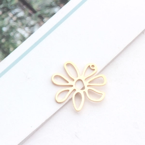 Détail macro d'un pendentif fleur évidé plaqué or 14 carats avec pétales de marguerites