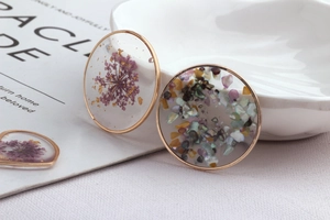 Handmade resin dried flower and gold foil pendants in heart and round shapes