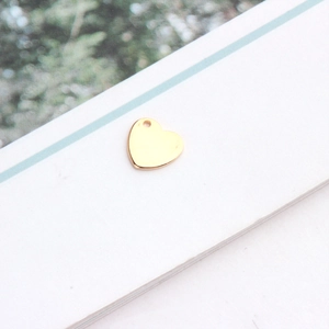 Détail d'un pendentif en forme de cœur plaqué or avec une finition miroir polie