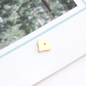 Vue macro d'un pendentif coeur plaqué or pour la création de bijoux DIY sur carte