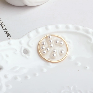 Macro shot of gold-plated circular pendant featuring multiple embedded white pearls
