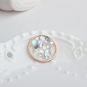 Detailed macro view of round gold frame pendant with iridescent shell inlays on porcelain