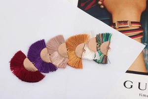 Close-up of colorful fan-shaped tassel pendants with gold clips for DIY jewelry making