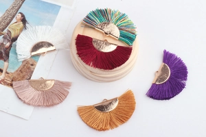 Macro detail of multi-colored half-circle cotton tassels with gold metal caps for DIY jewelry