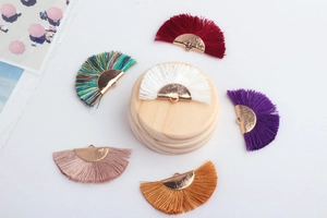 Macro shot of colorful fan-shaped tassel pendants with gold metal clips for DIY jewelry