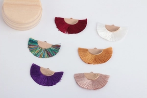 Macro shot of colorful fan-shaped tassel pendants with gold metal caps for DIY jewelry