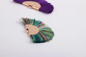 Macro detail of fan-shaped multi-color and purple tassels with rose gold metal caps