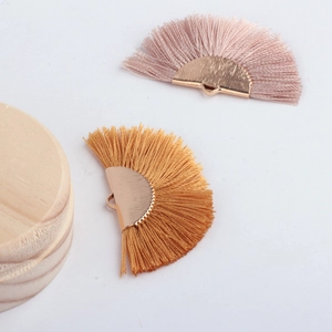 Close-up of semi-circular fan fringe pendants in pink and yellow for DIY jewelry making