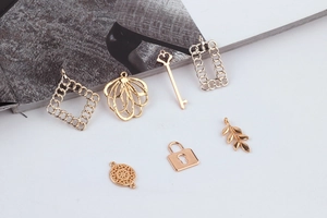 Close-up of assorted gold and silver alloy DIY jewelry charms including keys and locks