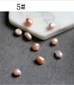 Detailed view of natural irregular pink baroque pearls on a textured stone surface