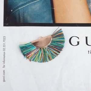 Close-up of a colorful semicircular tassel pendant with a golden metal clasp for DIY crafts