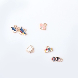 Detailopname van Japanse legering bedeltjes met waaiers en kimono-pop ontwerpen