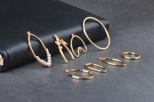 Close-up of golden geometric alloy earring charms and pearl pendant for DIY jewelry