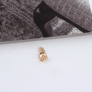 Detailed view of a golden fist-shaped metal pendant charm for DIY jewelry making