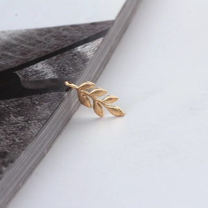 Detailed macro view of a golden leaf-shaped DIY jewelry pendant with matte finish
