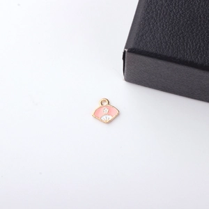 Detail van roze en witte emaille waaier hanger met witte bloem en gouden randafwerking