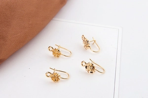 Close-up of gold-plated flower-shaped DIY earring hooks with intricate petal details