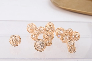 Detalle macro de perlas envueltas en alambre dorado para la fabricación de pendientes de bricolaje