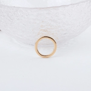 Detailed view of polished gold geometric earring pendant with a smooth metallic finish