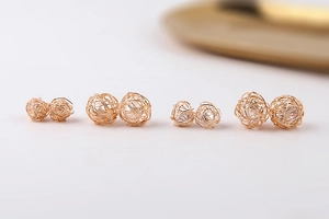 Detalle de esferas de alambre dorado tejidas a mano con perlas y circonitas