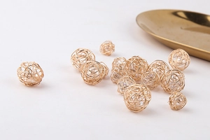 Detalle de bola hueca de alambre dorado con perla para creación de joyas DIY