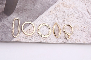 Detailed close-up of golden irregular geometric metal pendants for DIY jewelry making