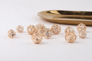 Detalle de esferas huecas de hilo dorado con perlas para crear joyas de bricolaje